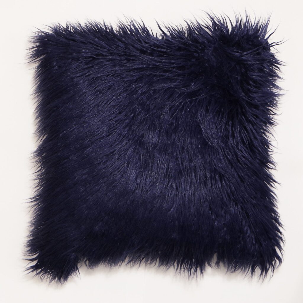 Close-up of a navy blue faux-fur cushion against a white background.