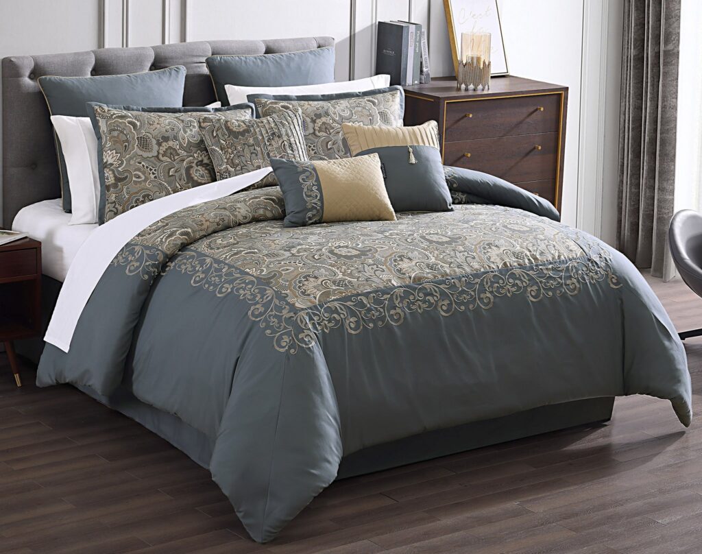 Luxurious bed with teal and gray patterned bedding and multiple decorative pillows in a stylish bedroom.